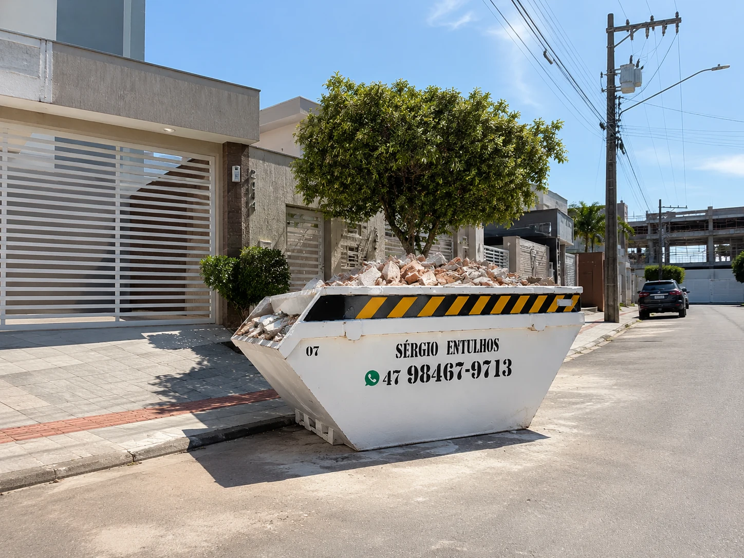 Caçamba real da Sérgio Entulhos posicionada em rua residencial