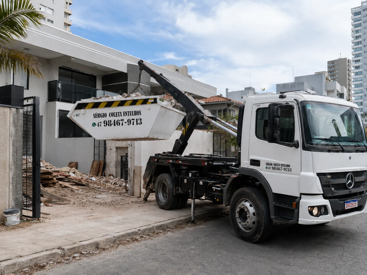 Caminhão da Sérgio Entulhos retirando caçamba em obra